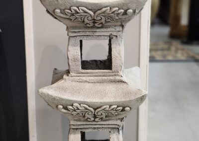 A decorative stone lantern with intricate carvings and square openings.
