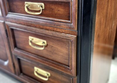 Close-up of wooden drawers with brass handles.