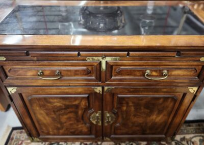 Antique wooden cabinet with brass handles and locks.