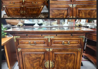 Vintage wooden cabinet with intricate brass handles and rich wood grain.
