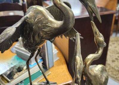 Bronze crane statues on a wooden surface.