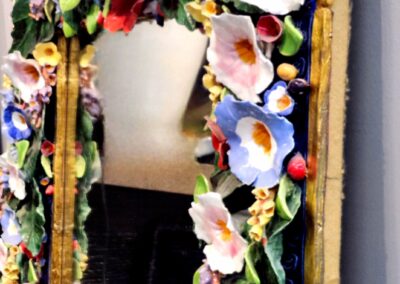Colorful floral garland draped over a mirror frame.