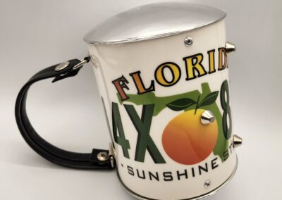 A Florida souvenir pitcher with an orange design and black handle.