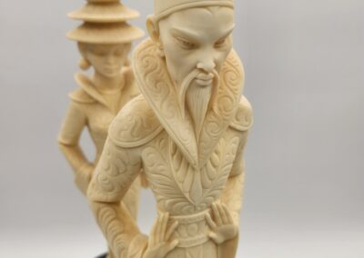 Intricately carved ivory chess pieces depicting ancient Chinese figures.