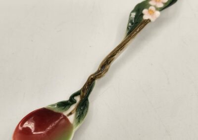 Decorative ceramic spoon with floral design and vibrant colors.