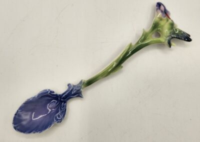 A purple flower with a twisted stem against a plain background.