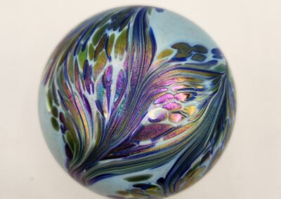 A colorful glass paperweight with intricate floral designs.