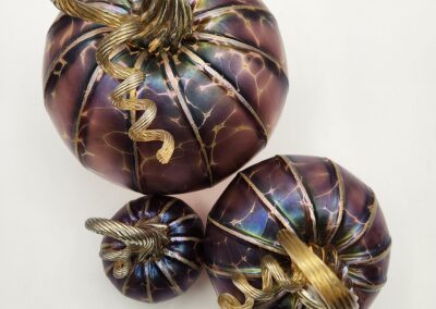 Three decorative pumpkins with metallic gold stems and accents.