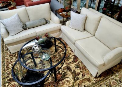 Cozy living room with beige sectional sofa and glass coffee table on patterned rug.