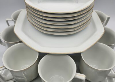 Stacked white dishes and cups set.