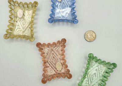 Four colored glass dishes with coin.