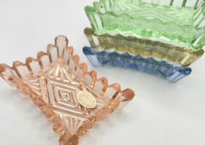 Colorful glass trays with coin on top.