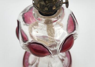 Vintage glass oil lamp with red accents.