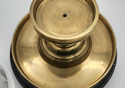 Golden brass pedestal with circular design.