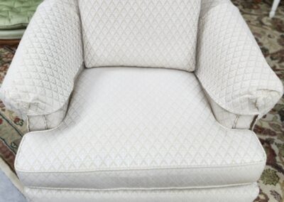 Beige patterned armchair on patterned rug.