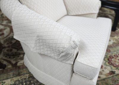 Beige upholstered armchair on patterned rug.