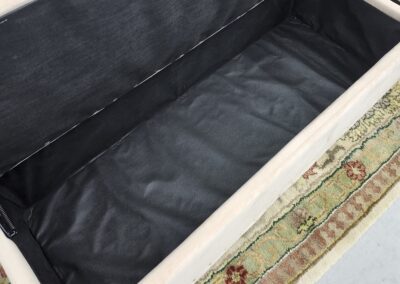 Open storage ottoman on patterned rug.