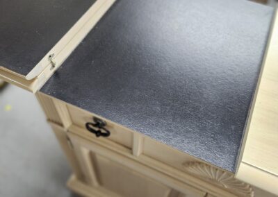 Wooden cabinet with open black tabletop extension.