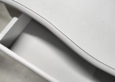 Open white drawer with curved handle.