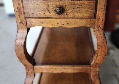 Wooden side table with drawer and shelves.