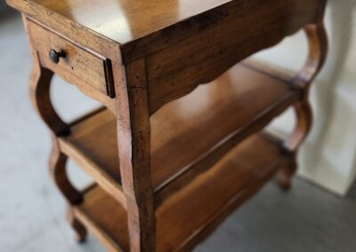 Wooden three-tier shelf with curved legs.