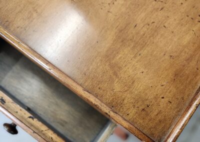 Open wooden drawer on antique table.