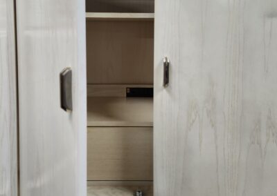 Open wooden wardrobe with shelves and drawers.