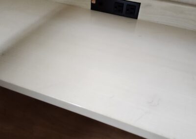 Wooden desk with built-in electrical outlets.