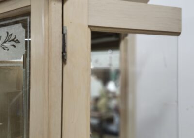 Wooden cabinet with open glass door.