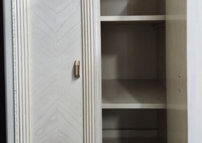 White cabinet with open door and shelves.