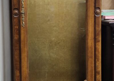 Tall wooden display cabinet with glass doors.