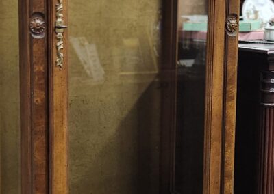 Tall wooden cabinet with glass doors.
