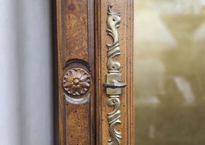 Ornate wooden door with brass handle.