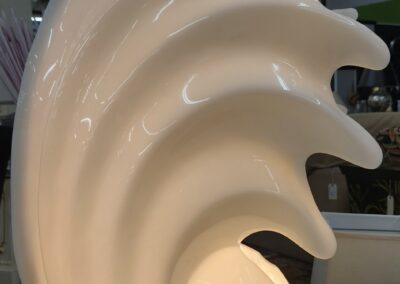 Sculptural white lamp with swirling design.
