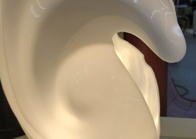 Abstract white sculpture with swirling design.