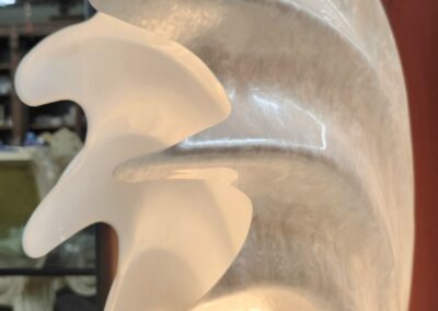 Abstract white sculpture with swirling design.