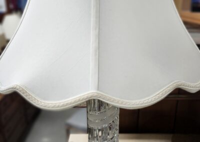 White lampshade with glass base on table.
