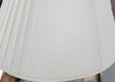 White lampshade on decorative metal base.