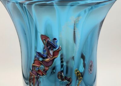 Blue glass vase with colorful abstract patterns.