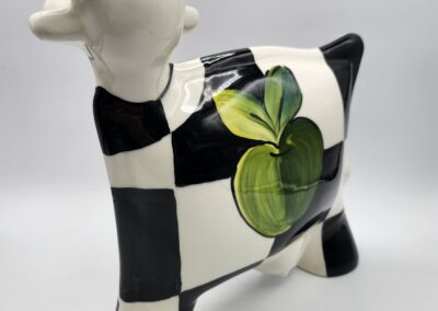 Ceramic cow with checkerboard pattern design.