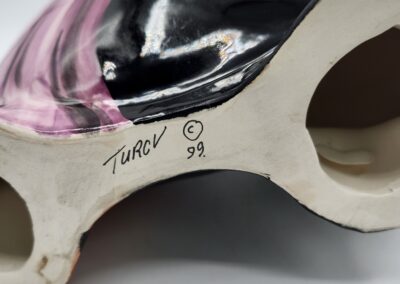 Colorful ceramic object with artist signature.