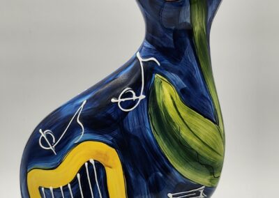 Ceramic cat sculpture with tulip and harp.
