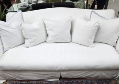 White sofa with five decorative pillows.