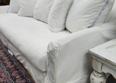 White sofa with pillows, vintage decor setting.