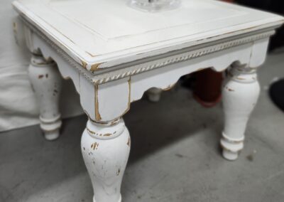 Distressed white wooden table with vase.