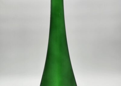 Tall green glass bottle on white background.