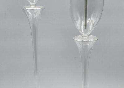 Two tall, elegant glass candle holders.