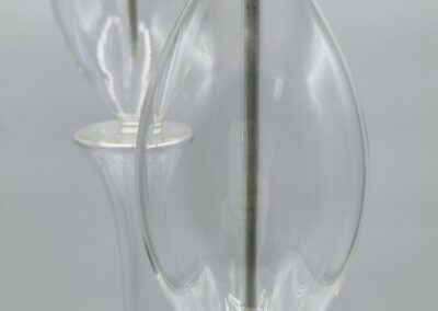 Two clear glass oil lamps, unlit wicks.