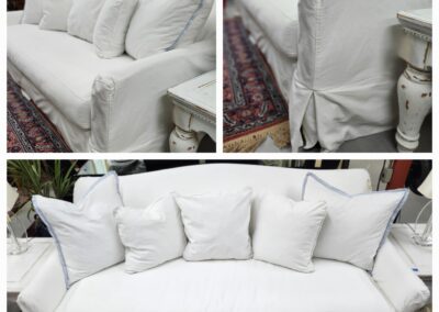 White sofa with multiple cushions displayed.