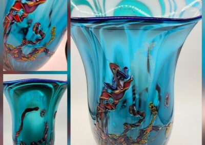Blue glass vase with abstract colorful design.